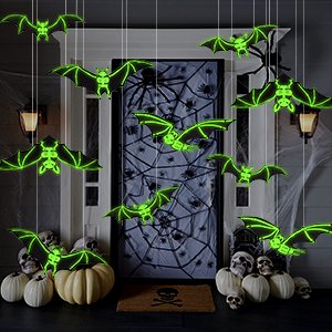 Halloween hanging bats decorations with glowing green outlines, displayed outdoors on a porch with pumpkins and skulls.