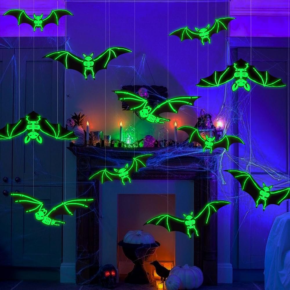 Hanging glowing skeleton bats decoration for Halloween, displayed indoors with cobwebs and pumpkins.