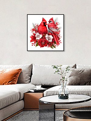 Diamond painting kit featuring two red cardinals surrounded by red and white flowers, displayed on a wall above a sofa.