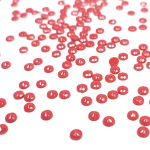 Scattered red round diamond painting drills on a white background, close-up shot with shallow depth of field.