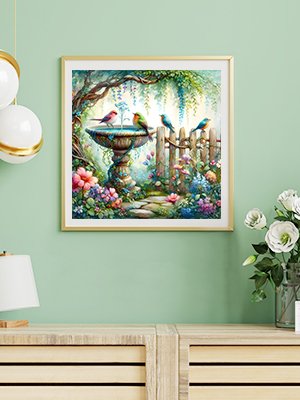 Diamond painting kit featuring a bird bath with four birds in a garden setting with flowers and a fence.