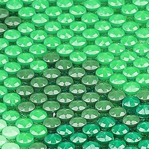 Close-up of a diamond painting kit with green faceted beads arranged in a bird landscape pattern.