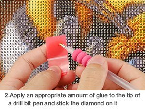 Close-up of hands applying a diamond to a 5D diamond painting kit with a pink drill pen.