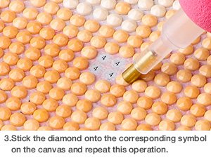 Diamond painting kit close-up showing a tool placing a round diamond onto a canvas with a bee and sunflower pattern.