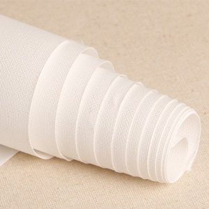 Rolled up white canvas fabric on a neutral textured surface, close-up detail.