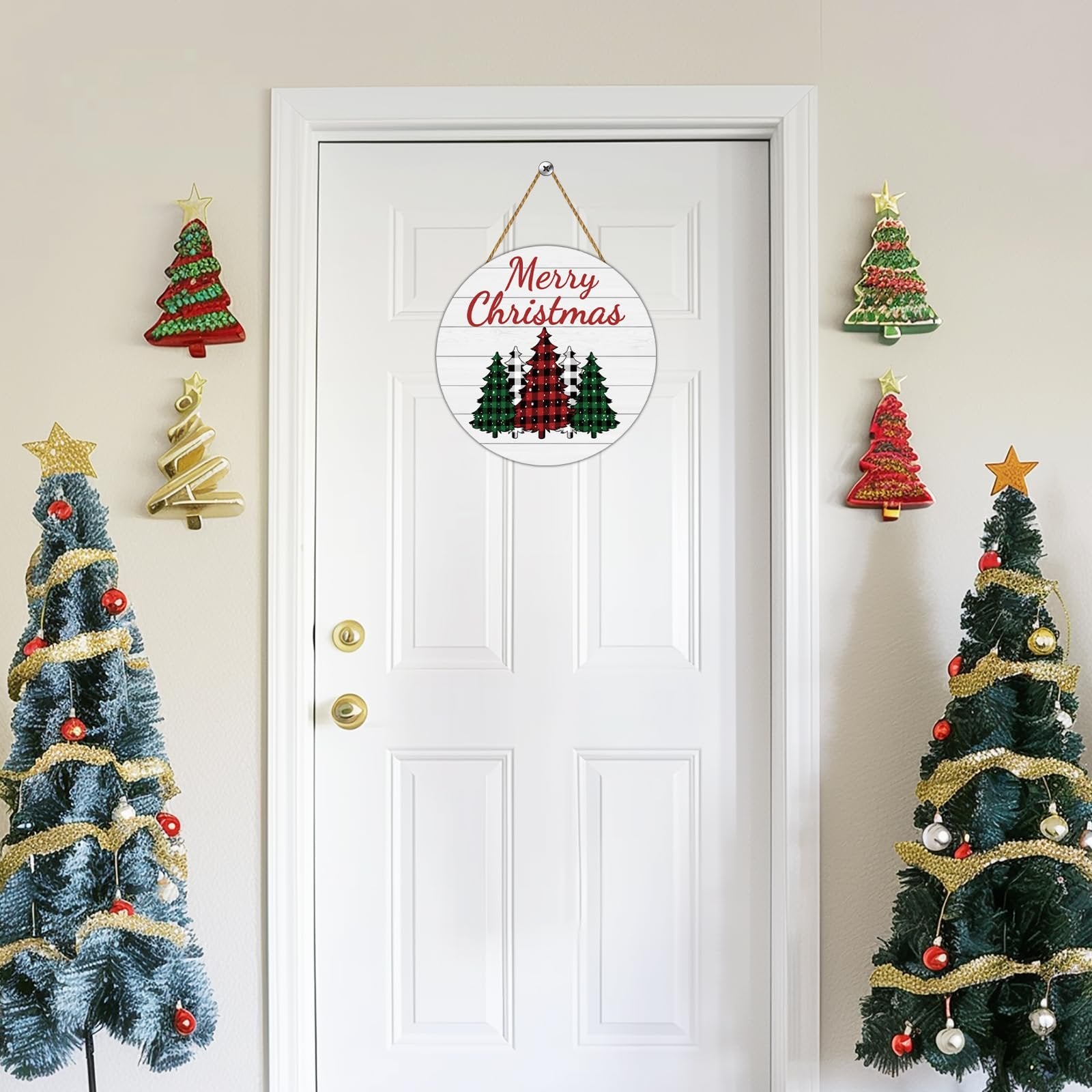 Round buffalo plaid Christmas tree door sign with Merry Christmas text, hanging on a white door with decorative Christmas trees on either side.