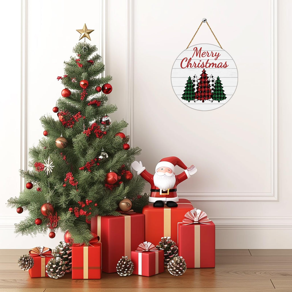 Round buffalo plaid Christmas tree door sign hanging on a wall next to a decorated Christmas tree and gifts.