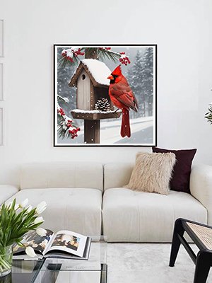 Diamond painting of a cardinal on a snow-covered birdhouse, displayed in a modern living room.