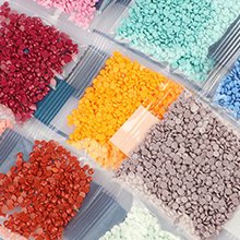 Close-up of colorful diamond painting beads in individual plastic bags, arranged in a grid pattern.