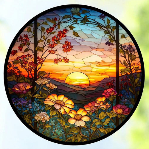 Circular stained glass panel depicting a vibrant sunset over mountains with blooming flowers in the foreground.