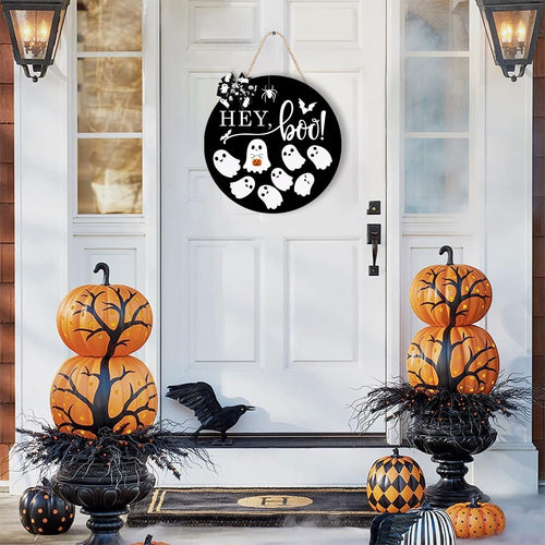 Round black Halloween door sign with ghosts and 'Hey Boo' text hanging on a white door.