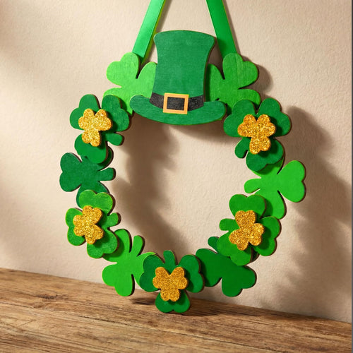 Wooden St. Patrick's Day wreath with green shamrocks and a leprechaun hat, hanging on a wall.