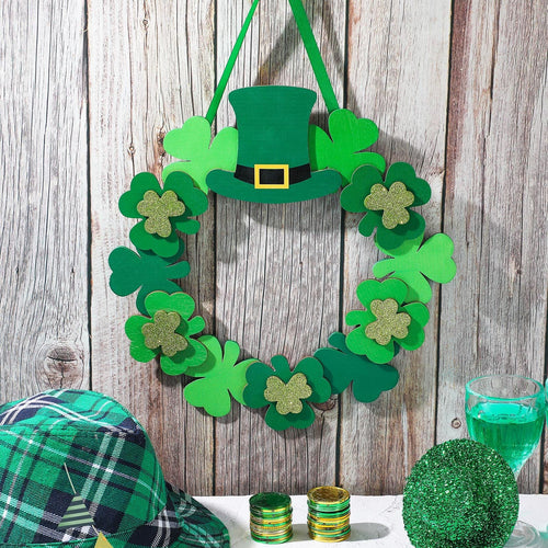 St. Patrick's Day wreath with shamrocks and a leprechaun hat, displayed with a plaid hat, gold coins, and a green drink.