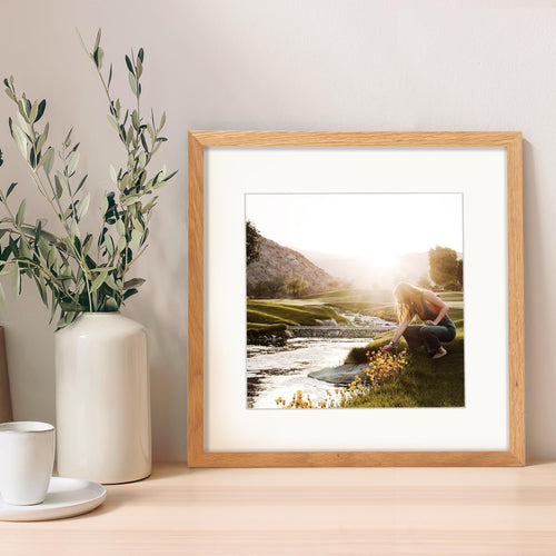 12x12 inch solid white oak picture frame displaying a landscape photo of a woman by a stream at sunset