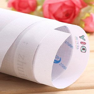 Rolled up diamond painting canvas with printed grid lines and small colorful icons, close-up view.