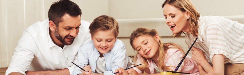 Family of four doing diamond painting kit together on the floor, smiling and engaged.