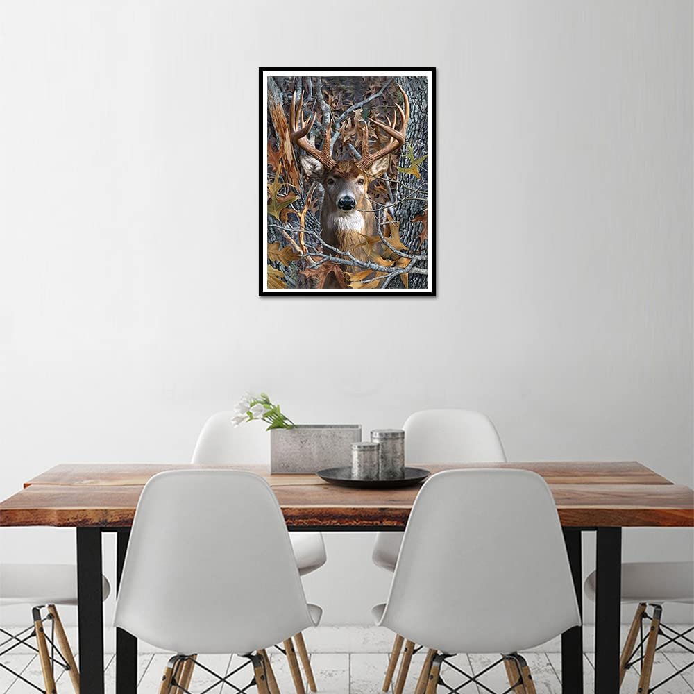 Framed 5D diamond art painting of a deer with large antlers in a forest setting with camouflage leaves.