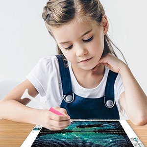 Young girl doing a 5D diamond painting kit of a starry night canoe lake landscape.