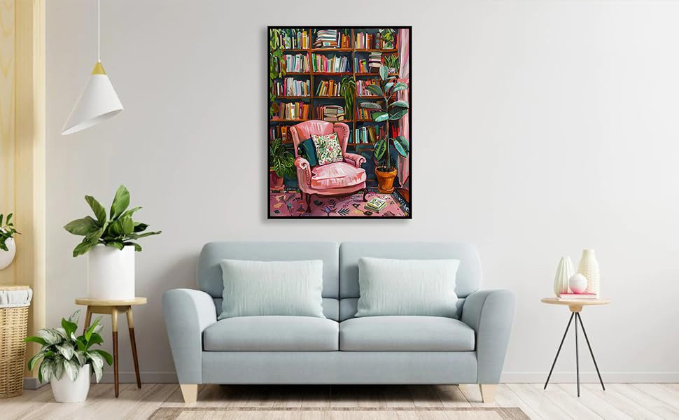 Framed diamond painting of a pink armchair in a room with bookshelves and plants, displayed above a sofa.