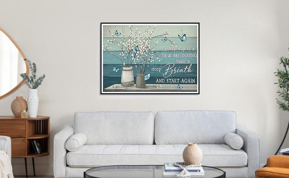 Diamond painting kit with blue butterflies and floral branches on a wooden background, framed and hung above a sofa.