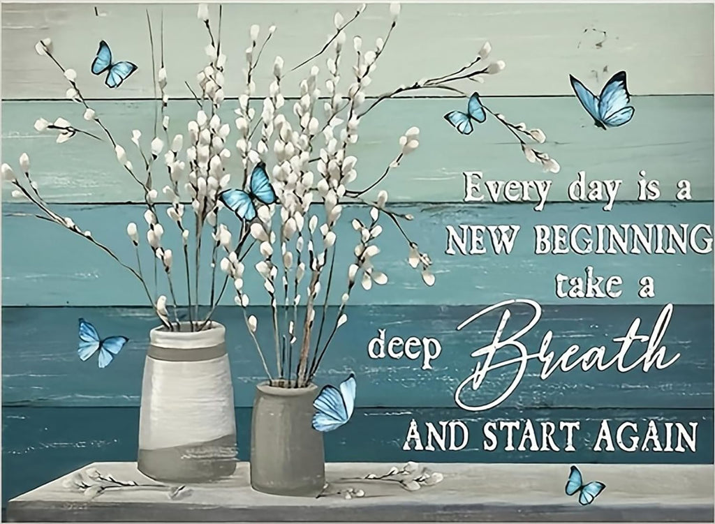 Two vases with white pussy willow branches and blue butterflies against a teal and light blue wood plank background.