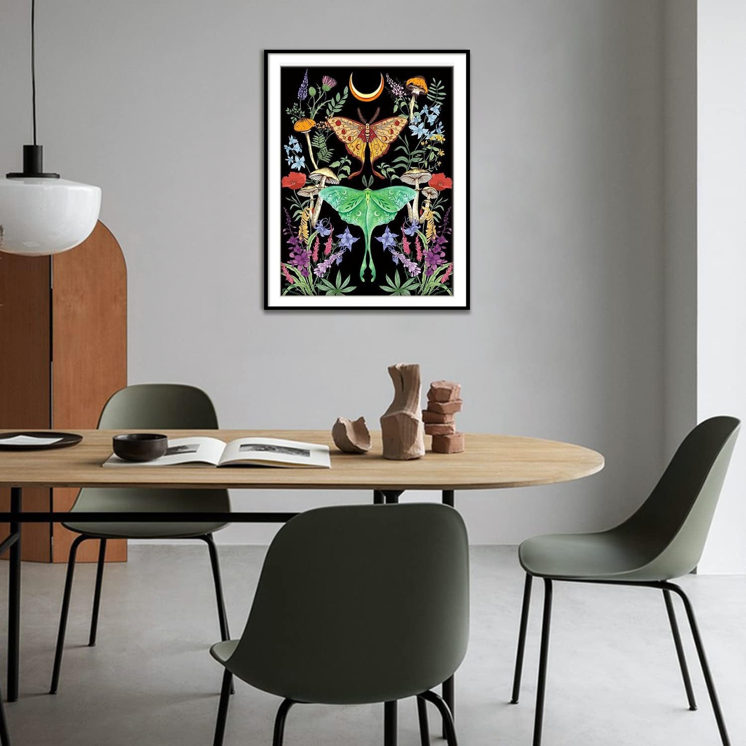 Diamond art kit with luna moth, butterfly, moon, mushrooms, and flowers on black background, framed and hanging on a wall.
