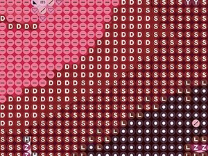 Close-up of a diamond painting canvas showing a pattern of letters and symbols in pink, red, and white.