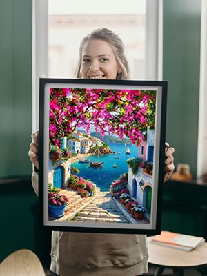 Woman holding a framed 5D diamond painting of a coastal village with pink flowers and boats