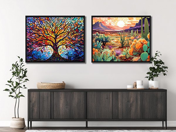 Two framed diamond art paintings displayed on a wall above a dark wood credenza, one of a colorful tree of life and the other a desert landscape.