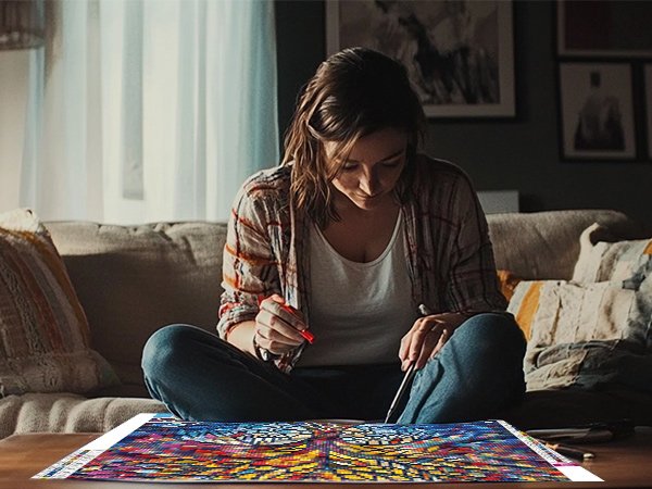 Woman sitting on a couch doing a colorful diamond painting kit on a table