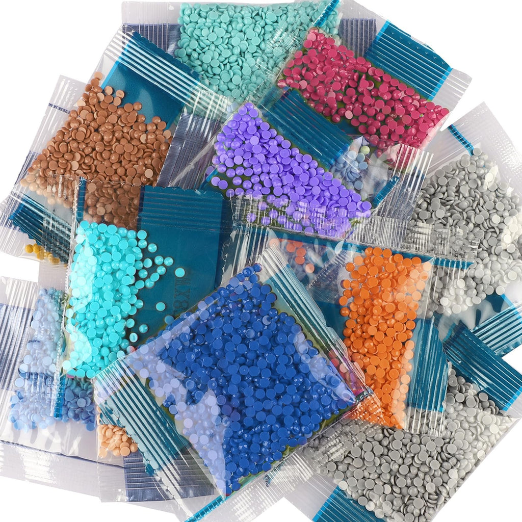 Pile of small, colorful diamond painting beads in clear plastic bags against a white background.