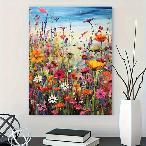 Colorful wildflowers painting on canvas, displayed on a wall above books and a vase.