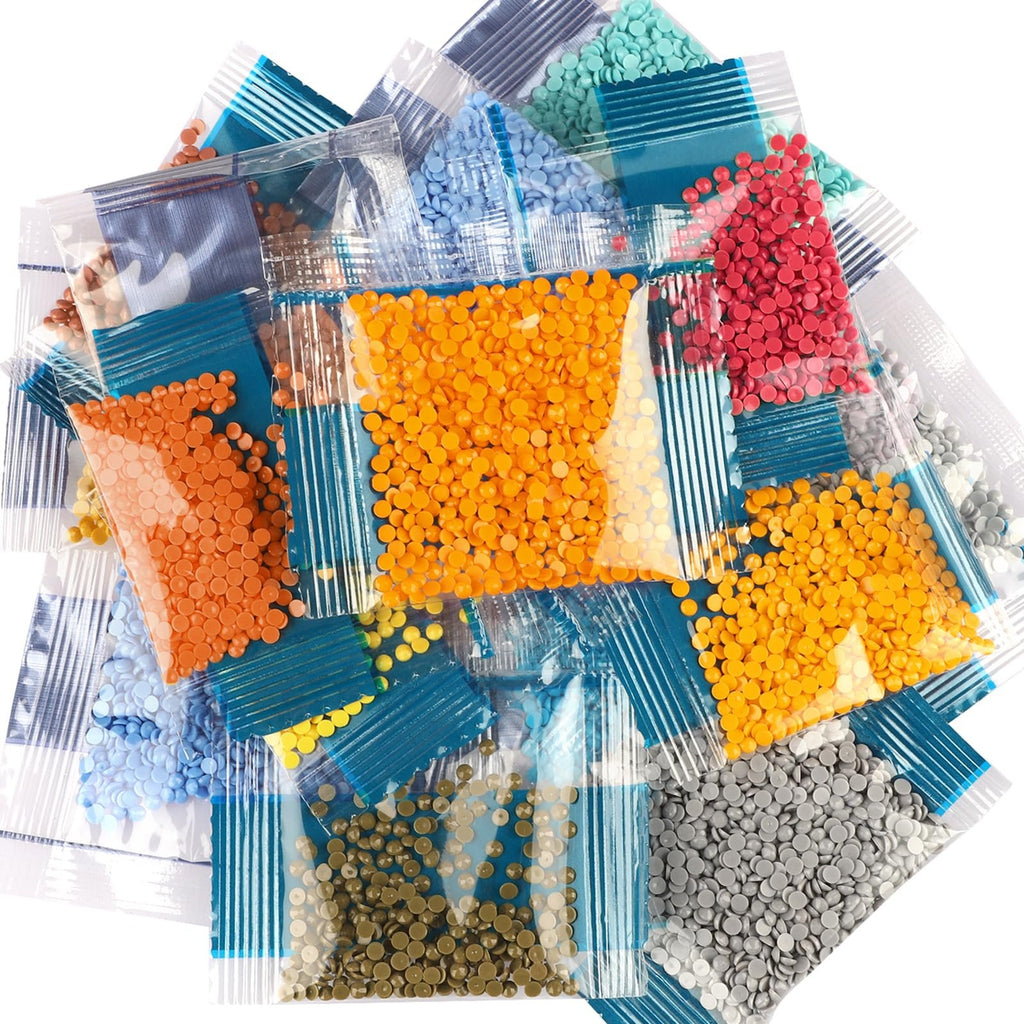 Pile of small plastic bags filled with colorful round diamond painting beads in orange, red, blue, green, yellow, brown, and gray.