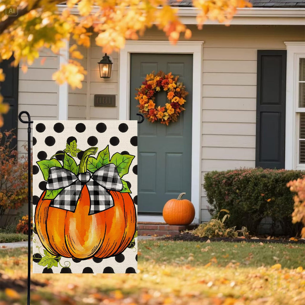 Garden flag with a pumpkin and black polka dots displayed in front of a house with a wreath on the door.
