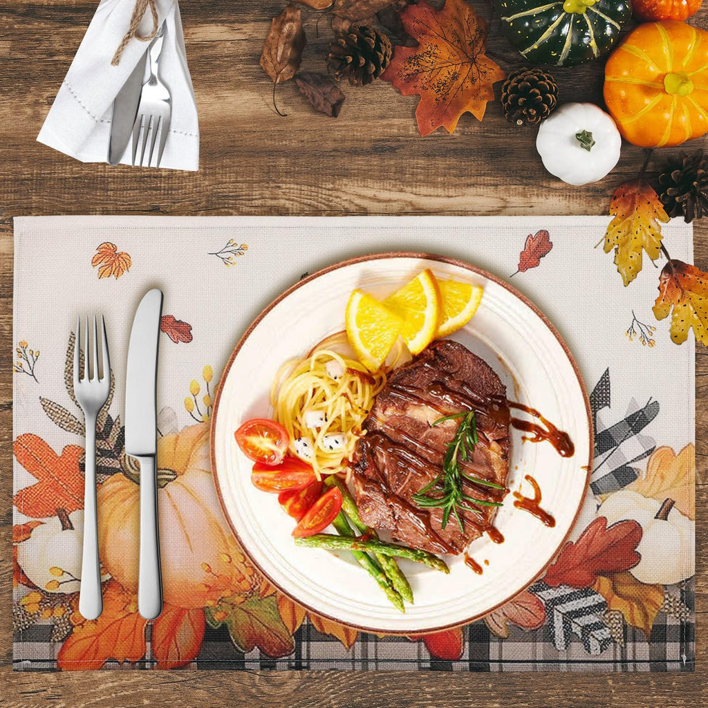 Autumn placemat with pumpkins and maple leaves, set with a plate of steak and pasta, and cutlery.