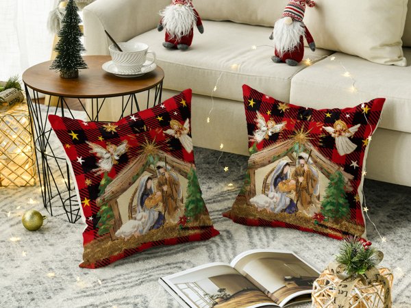 Two Christmas nativity scene pillow covers with red plaid border on a rug with festive decor