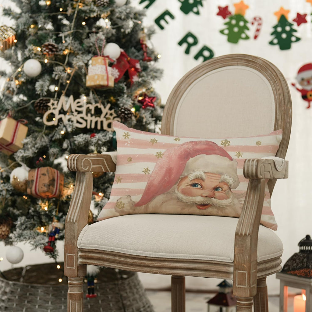 Christmas pillow cover with Santa Claus design on a chair next to a decorated Christmas tree.