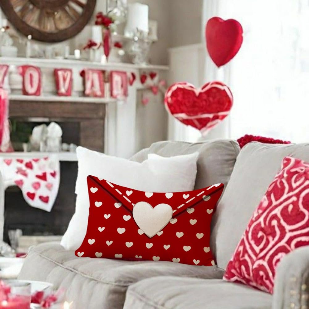 Red lumbar pillow cover with white hearts and a cream heart accent, on a sofa with Valentine's decor.
