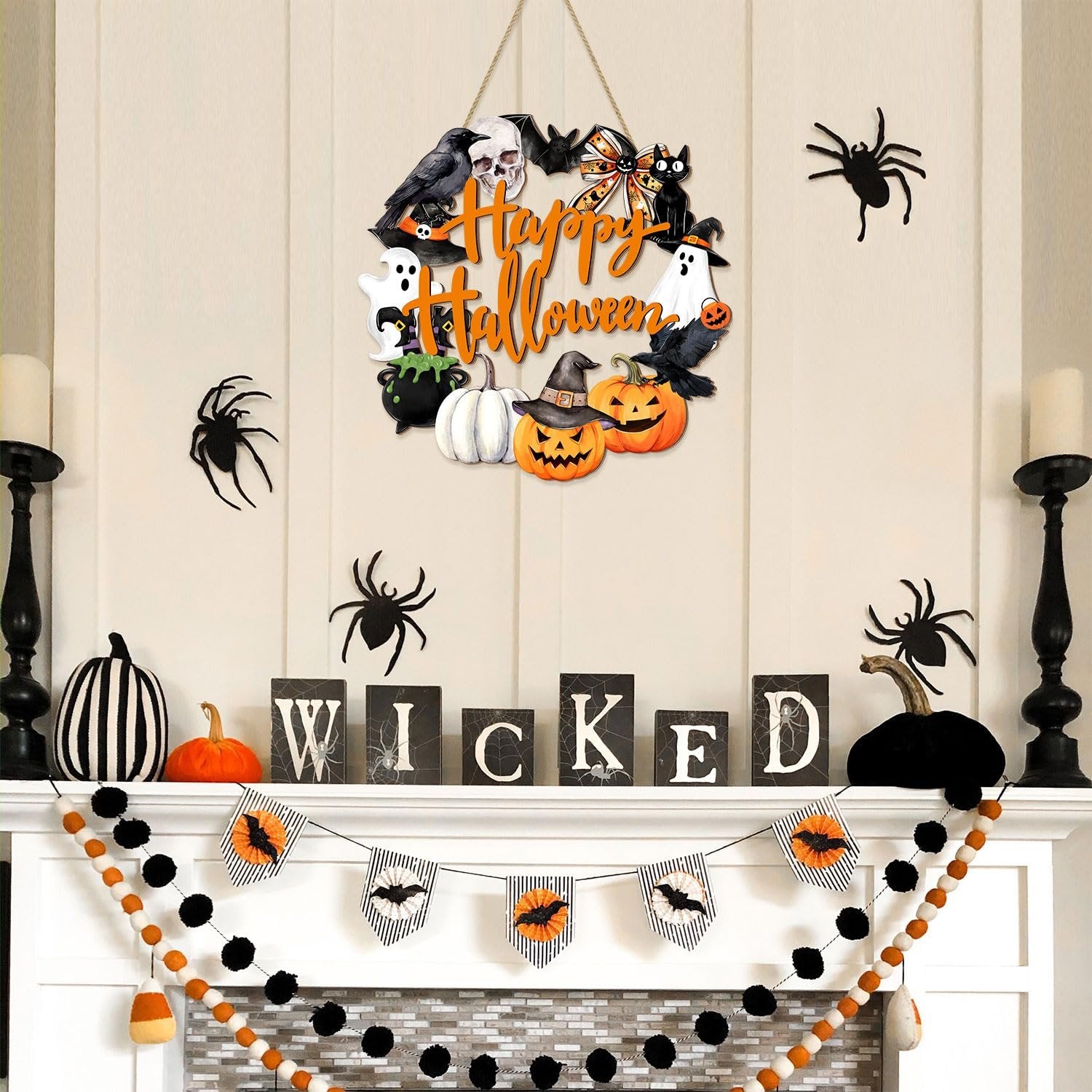 Happy Halloween door sign with ghost, black cat, pumpkin, skull, cauldron, witch hat, bow, and wreath decorations hanging above a fireplace mantel.