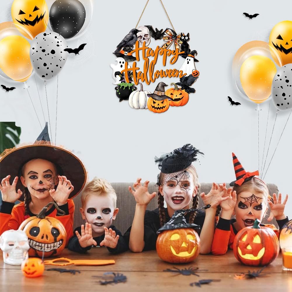 Four children in Halloween costumes posing with pumpkins and a door sign