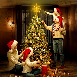Family decorating a Christmas tree with a gold star topper illuminated by 20 LED lights.