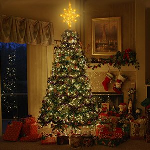 Gold star Christmas tree topper with 20 LED lights atop a decorated Christmas tree with presents underneath.