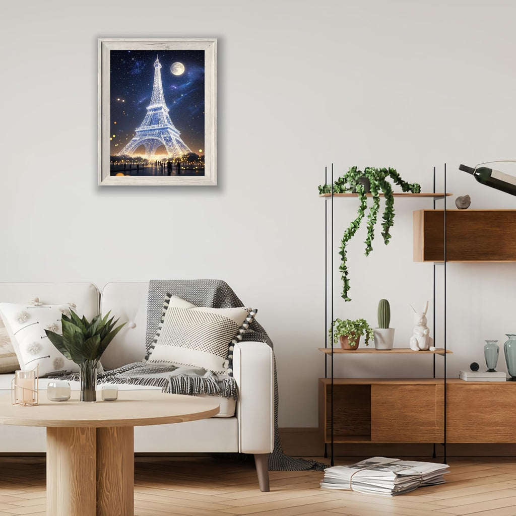 Framed diamond art painting of the Eiffel Tower at night with a full moon, displayed on a wall above a sofa.