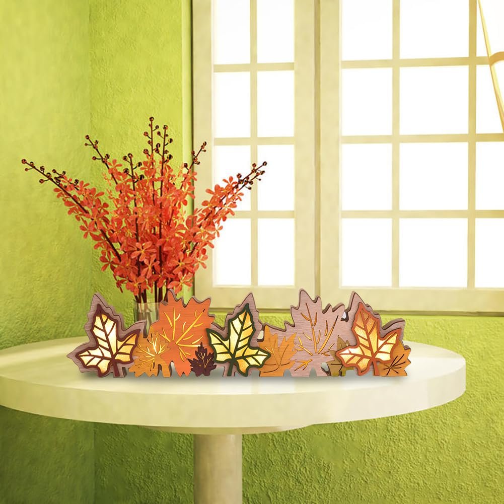 Wooden maple leaf centerpiece with LED lights on a table with floral arrangement