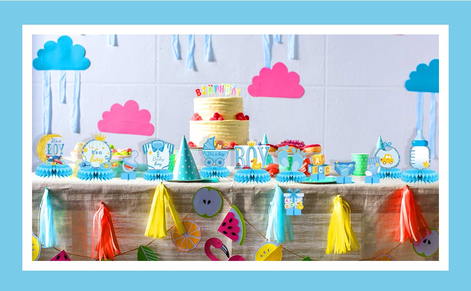 Baby shower table decorations with honeycomb centerpieces, cake, and party hats.