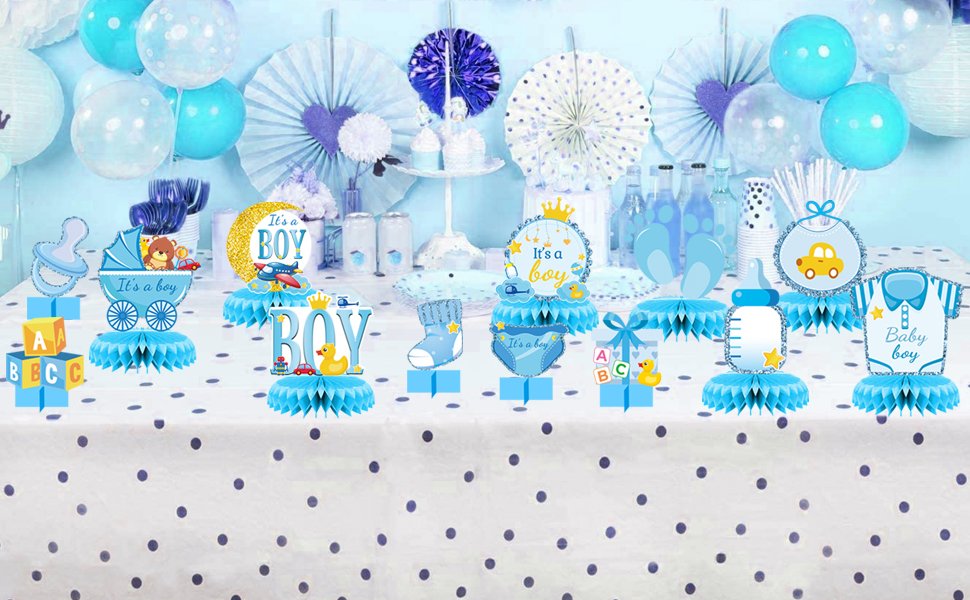 Table decorated with blue and white honeycomb centerpieces for a baby boy party, featuring baby items and balloons.