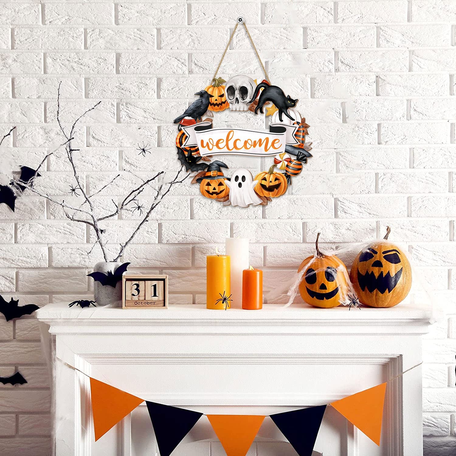 Halloween wreath sign with ghost, pumpkin, skull, black cat, and crow decorations hanging above a fireplace mantel.