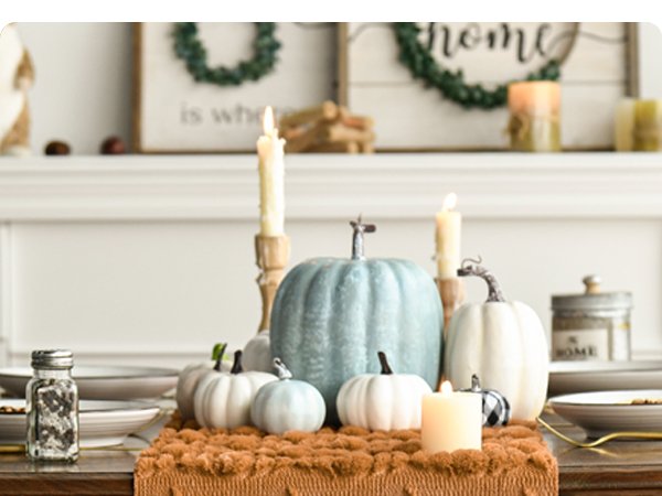 Fall table setting with pumpkins and candles on a caramel faux fur table runner.