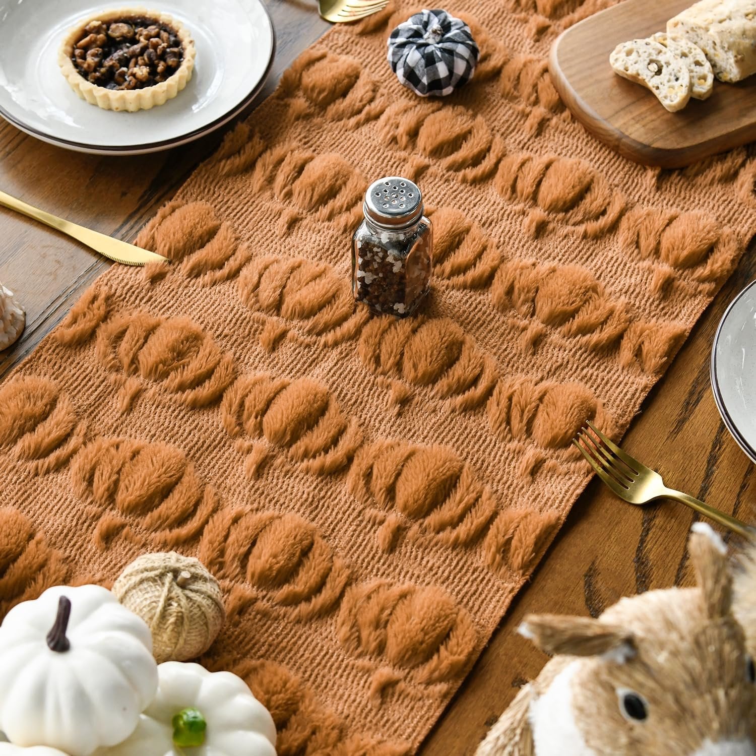Caramel faux fur table runner with embossed pumpkin pattern on a wooden table with fall decor