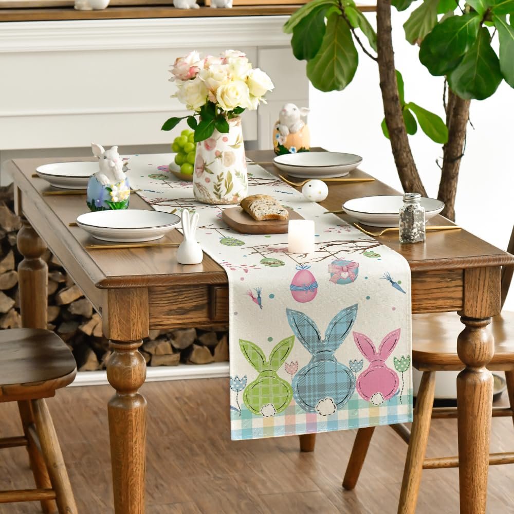 Easter table runner with plaid bunnies, eggs, and carrots set on a dining table with place settings and a floral centerpiece.